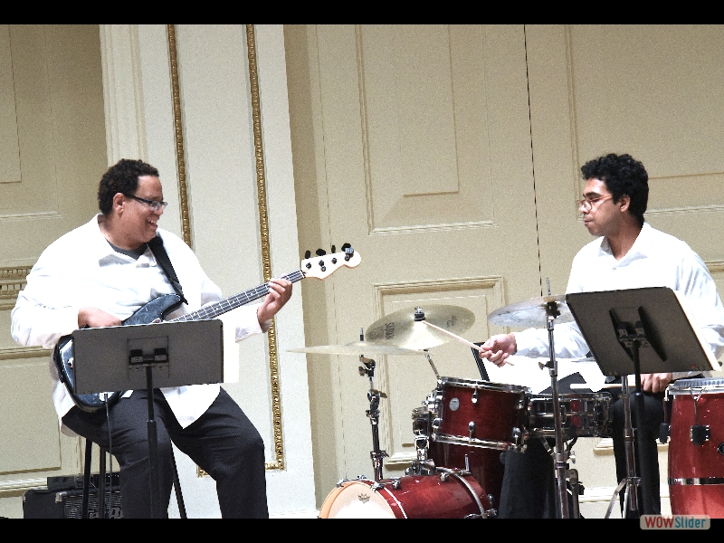September 21, 2018: Grounding the concert onto a solid Latin groove foundation: the fabulous electric bassist John Benitez and his talented son Francis Benitez on drums. Photo: Melanie Futorian.